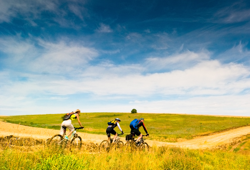 Ciclisti, colline, cielo