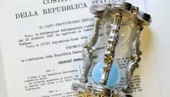 Foto dell'evento: una clessidra appoggiata sul testo della Costituzione Italiana