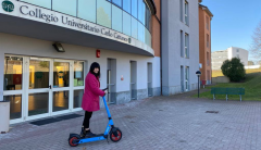 Foto di ragazza su monopattino davanti al Collegio