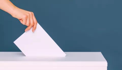 mano che infila scheda elettorale nell'urna