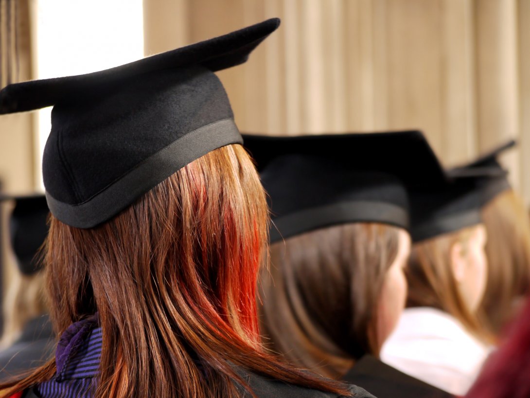 Foto del banner: ragazza con toga e tocco alla cerimonia di laurea