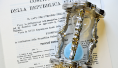 Foto dell'evento: una clessidra appoggiata sul testo della Costituzione Italiana