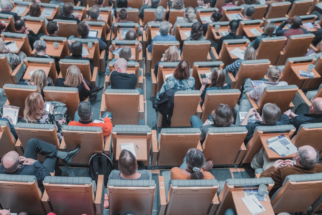 Foto scattata dall'alto che ritrae una platea di studenti seduti in un'aula