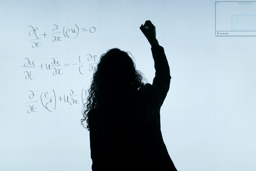 Foto di una donna che scrive su una lavagna