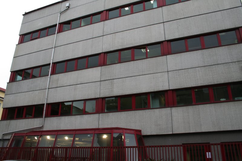 Edificio Oriani, via Bossi - Como Edificio grigio con profili delle finestre rossi, cancellata rossa